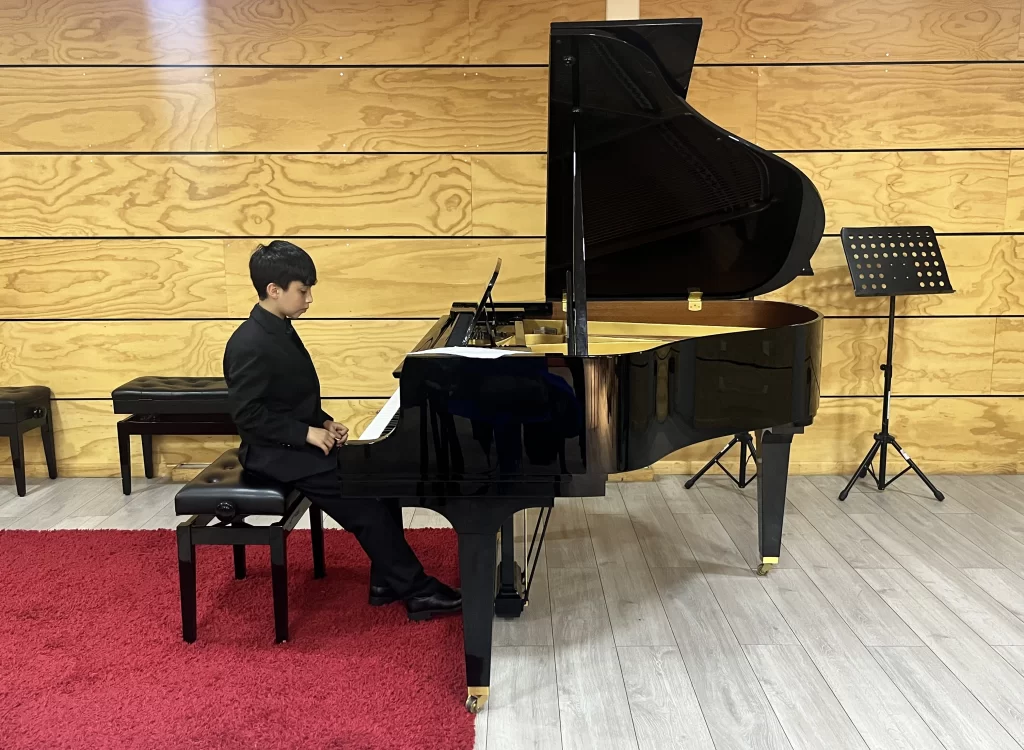 Niño pianista tocando en un piano de cola