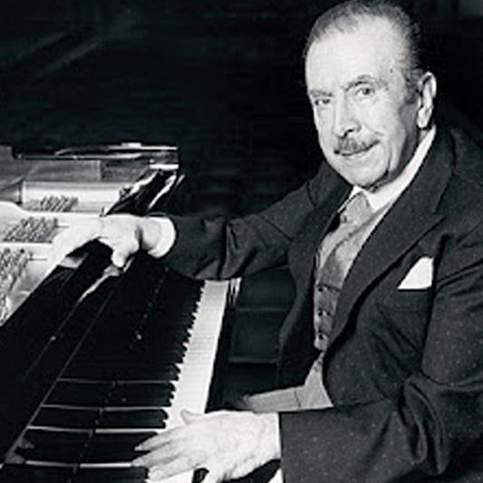 Fotografía de Claudio Arrau en blanco y negro junto a su piano