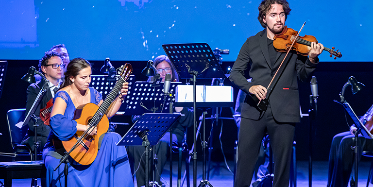 Artistas italianos: Carlotta Dalia se encuentra tocando guitarra y Giuseppe Gibboni violín.